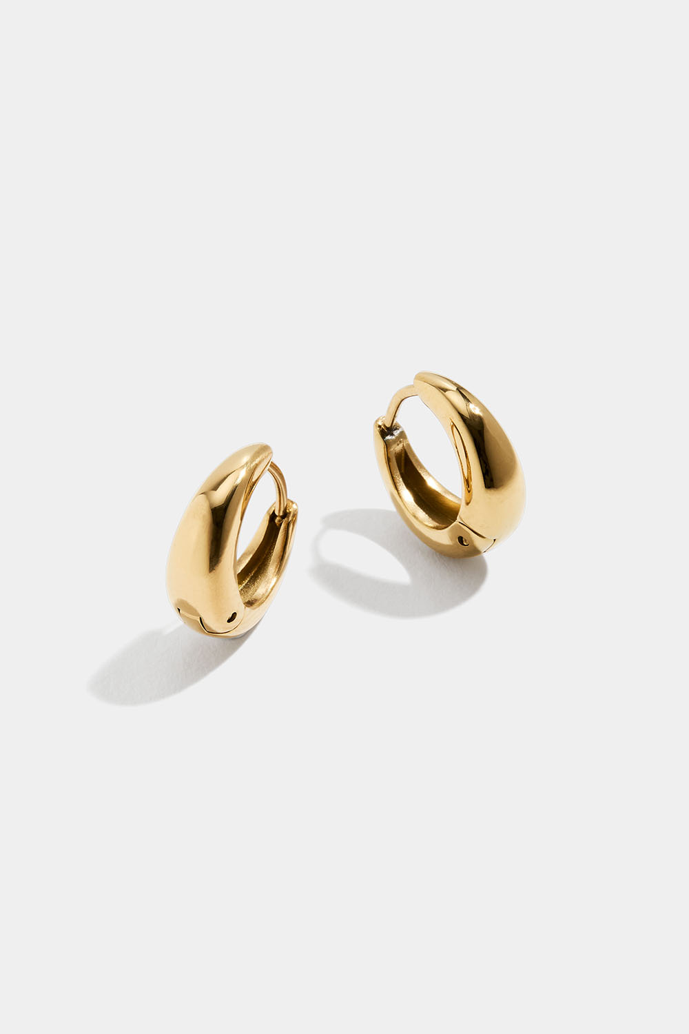 Små, dråpeformede øreringer i stål med 18 karat gull