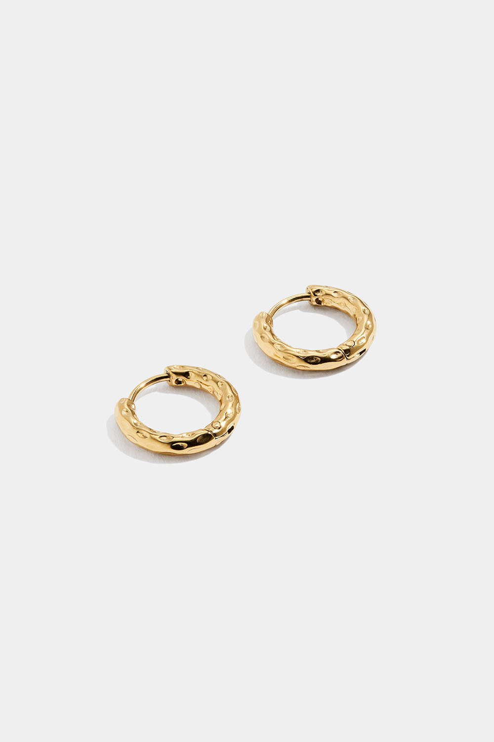 Små, hamrede øreringer i stål med 18 karat gull